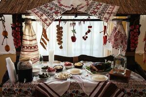 cossaco mesa dentro a melhor restaurantes. festivo mesa às uma casamento. bordado ucraniano toalha. vermelho e Preto cor. tradições. nacional ucraniano cozinha. gordo, salsichas, álcool. refeições. foto