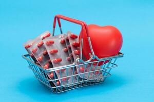 comprando medicação. droga vício conceito. pílulas e cápsulas dentro compras cesta em azul fundo. global farmacêutico indústria e grande farma. encomenda farmacêutico produtos foto