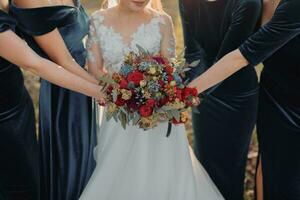 noiva com damas de honra em a parque em a Casamento dia. damas de honra dentro azul vestidos e noiva segurando lindo buquês. lindo luxo Casamento blog conceito. verão casamento. foto