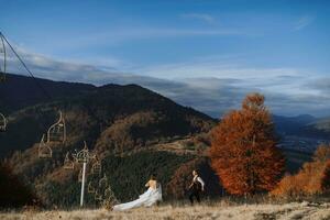 uma casal dentro amor dentro a montanhas. Casamento dentro a montanhas. recém-casados ter Diversão contra a fundo do montanhas e apreciar a visualizar. foto