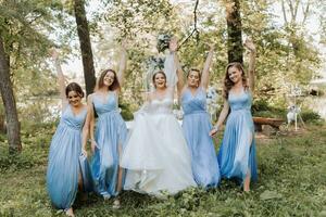a damas de honra dentro azul vestidos, a noiva é segurando uma lindo ramalhete. lindo luxo Casamento blog conceito. Primavera casamento. foto