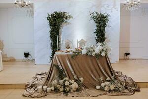 Casamento mesa servindo. Casamento luxo decoração. Casamento presídio para a recém-casados. lindo decoração com pastel rosas, velas e vegetação. dentro de casa foto