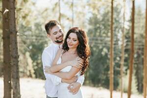 jovem feliz casal dentro amor abraçando sorridente e tendo Diversão dentro a montanhas. Alto qualidade foto. uma menina dentro uma lindo branco vestir foto