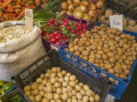 uma variedade do fresco frutas, sementes, nozes e legumes em exibição às a mercado. Comida foto