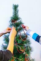 fechar acima tiro do mulher e pequeno Garoto decoração Natal árvore. feriado foto