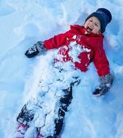 pequeno menina jogando neve anjo foto