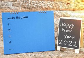 feliz ano novo de 2022 placa preta e lista de plano de calendário para fazer para segundo plano foto