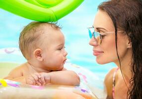 lindo mãe com filho dentro a piscina foto