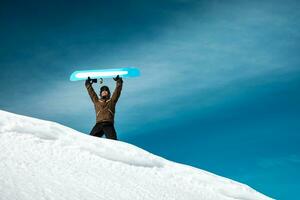 feliz homem com snowboard dentro a montanhas foto