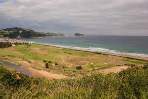 panorâmico Visão do Zarautz com guetaria em a fundo em uma brilhante ensolarado verão dia. foto