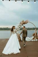 a primeiro Casamento dança do a noiva e noivo em a cais perto a rio foto