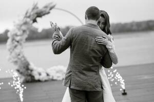 a primeiro Casamento dança do a noiva e noivo em a cais perto a rio foto