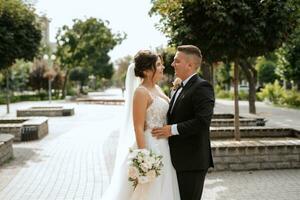 o noivo de terno marrom e a noiva de vestido branco foto