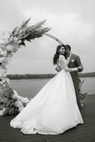 a primeiro Casamento dança do a noiva e noivo em a cais perto a rio foto