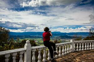 jovem mulher às uma ponto de vista sobre a lindo sopo vale às a departamento do cundinamarca dentro Colômbia foto