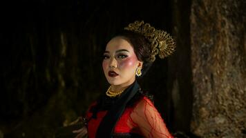 uma javanese dançarino vestido dentro tradicional vermelho roupas encantado a público com dela gracioso movimentos este misturado com a melodia foto