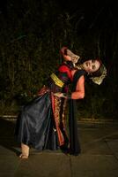 uma javanese dançarino danças dentro frente do a público com a ágil corpo dentro uma Preto traje foto