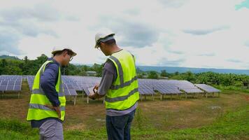 profissional ásia homem engenheiro usando digital tábua mantendo solar célula painéis juntos .técnico equipe trabalhando em ecológico solar Fazenda. foto