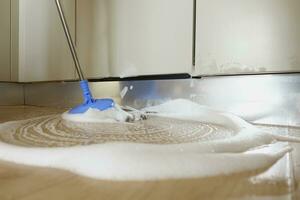 derramado água a partir de uma prato máquina de lavar em cozinha chão foto
