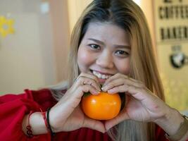 fêmea mulher senhora menina pessoa pessoas humano Veja às Câmera lindo bonita feliz sorrir retrato corpo parte mão símbolo coração amor laranja fruta laranja cor placa símbolo romântico estilo de vida moda foto