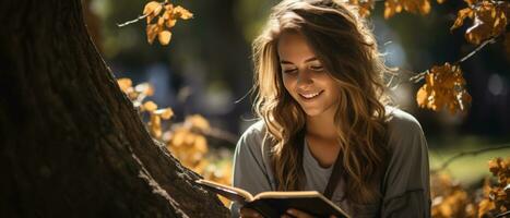 ai gerado retrato do uma jovem, feliz aluna lendo uma livro enquanto inclinado contra uma árvore dentro uma ensolarado parque. foto