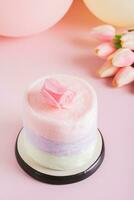 algodão doce bolo, flores, velas e balões para festa em mesa vertical Visão foto