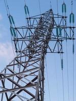 linhas de alta tensão elétrica e torres no fundo do céu azul foto