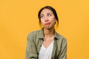 retrato de uma jovem senhora asiática com expressão negativa, animado, gritando, chorando com raiva emocional em roupas casuais, isolado em um fundo amarelo com espaço de cópia em branco. conceito de expressão facial. foto