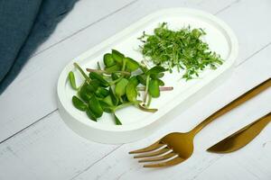 microgreens girassol e alfafa com talheres em a mesa. saudável vitaminas Comida conceito. foto