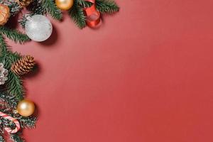 mínima criação plana lay de composição tradicional de Natal e temporada de férias de ano novo. vista superior decorações de Natal de inverno em fundo vermelho com espaço em branco para texto. copie a fotografia do espaço. foto