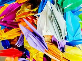 fechar-se colorida origami papel dentro pássaros forma fundo e papel de parede. foto