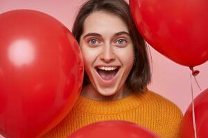 fechar-se retrato do jovem positivo fêmea, sente feliz e sorrisos amplamente. isolado sobre Rosa fundo foto