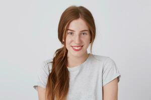 retrato do feliz lindo Yong mulher com grandes vermelho cabelo e sardas sorrisos e parece diretamente dentro Câmera isolado sobre branco fundo sente confiante foto