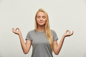 calma Loiras mulher meditando, tentativas para relaxar depois de grandes horas do estudo, sonhando sobre Bali, segurando dela mãos dentro ioga gesto, olhos fechado, isolado sobre branco fundo foto