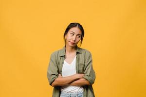 retrato de uma jovem senhora asiática com expressão negativa, animado, gritando, chorando com raiva emocional em roupas casuais, isolado em um fundo amarelo com espaço de cópia em branco. conceito de expressão facial.
