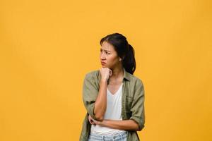 retrato de uma jovem senhora asiática com expressão negativa, animado, gritando, chorando com raiva emocional em roupas casuais, isolado em um fundo amarelo com espaço de cópia em branco. conceito de expressão facial.