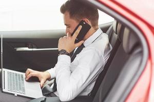 homem é um homem que trabalha em um laptop e testa em dispositivos móveis. foto