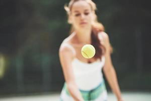 uma linda mulher vestindo uma bola de tênis sportswear.