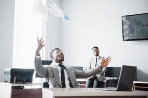 Dois celebração alegre empresário afro-americano bem-sucedida ao jogar papel no local de trabalho foto