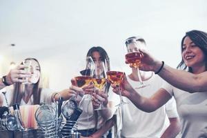 conceito de lazer e comunicação. grupo de amigos felizes e sorridentes, tomando drinks e conversando em um bar ou pub foto