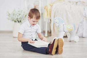 menino lendo um livro. educação, conhecimento, preparação para a escola