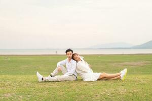 feliz jovem casal asiático em roupas de noivos foto