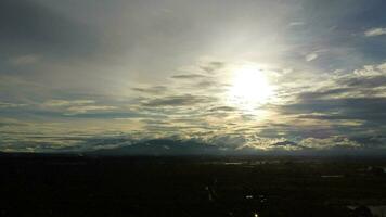 aéreo Visão do a inundado agrícola Campos contra a fundo do a sombras do a montanhas e a nublado céu às crepúsculo. lindo natureza do tempestade nuvens dentro a dia. foto