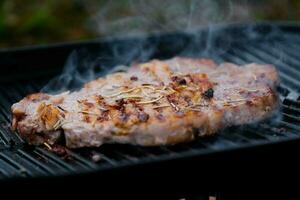 grelhado carne bife com especiarias em a grade com fumaça. foto