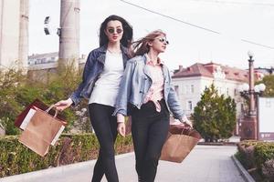 lindas garotas com sacolas de compras andando no shopping foto