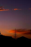 silhueta do uma torre contra a roxa céu foto