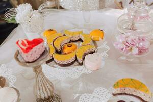 festivo sobremesa mesa com doces. Casamento doce bar, vários bolos, chocolates em fica. foto