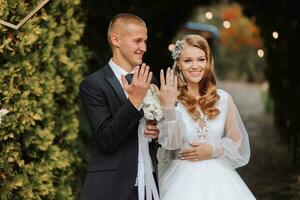 uma jovem Casamento casal às uma Casamento pintura cerimônia. a noiva e noivo mostrar seus Casamento argolas para a convidados foto