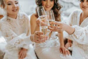 a noiva e dela amigas estão a comemorar seus Casamento dia dentro a sala. a menina a tarde antes a casamento. óculos fechar-se foto