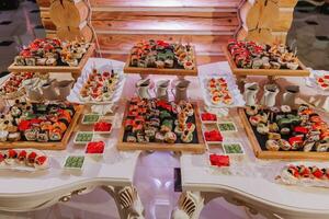 grande bufê recepção do diferente delicioso Comida às uma Casamento celebração. lanches para convidados. Casamento Festa. canapés, Sushi, fruta, carne, bebida, vinho, suco. foto